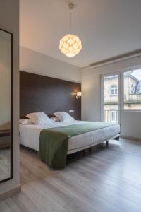 a bedroom with a large bed and a large window at Hotel Mendez Nuñez in Lugo