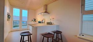cocina con 2 taburetes y barra en una habitación en Luxe woning met hottub en zeezicht VP074, en Wieringerwerf 29 fotos más
