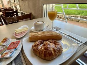 a table with a plate of bread and a glass of orange juice at Hotel Oreneta in Altafulla