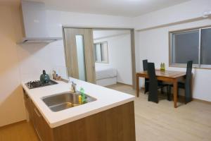 a kitchen with a sink and a dining room with a table at 位于新桥的2卧室公寓 in Tokyo +8 photos