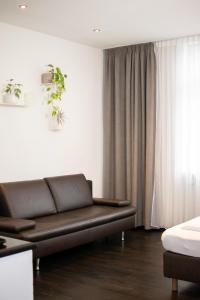 a living room with a brown couch in front of a window at meywohnen Prien am Chiemsee in Prien am Chiemsee +8 photos