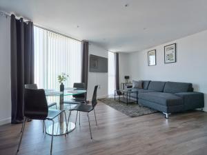 a living room with a couch and a table and chairs at Comfortable 3 bedroom apartment in Croydon