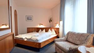 a hotel room with a bed and a couch at Hotel Pflum mit Gästehaus in Nürtingen