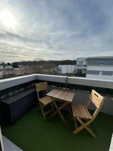 two chairs and a table on a roof at Appartement T3 proche circuit du Mans in Allonnes