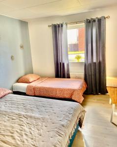 two beds in a room with a window at 5 minute walk to LEGO HOUSE - n18 in Billund