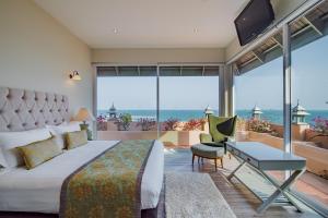 a bedroom with a bed and a desk with a view of the ocean at Anantasila Beach Resort Hua Hin in Hua Hin