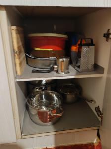 a shelf with pots and pans and other kitchen items at ΔΙΑΜΕΡΙΣΜΑ ΣΤΟ ΚΕΝΤΡΟ in Tripolis