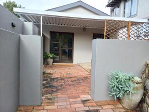 ein Haus mit einem weißen Zaun und einigen Pflanzen in der Unterkunft Buckingham Cottage in Pinetown