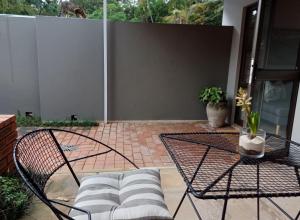 eine Terrasse mit einem Tisch, einem Stuhl und einem Sofa in der Unterkunft Buckingham Cottage in Pinetown + 2 Fotos