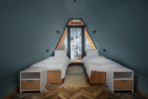 two beds in a room with a large window at Ari Home Aghveran in Aghveran