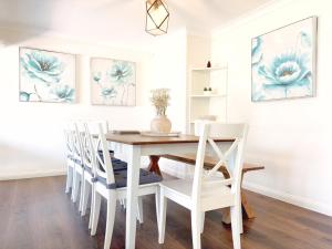 a dining room with a white table and chairs at Berkeley Waterfront - Family & Pet Paradise in Berkeley Vale +28 photos