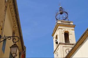 a tower with a clock on top of a building at L'écrin du Pont du Gard - Parking gratuit - Charme & Pierres in Remoulins +5 photos
