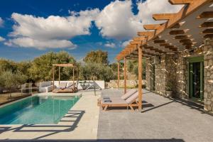 a patio with a swimming pool and a house at Athina Villa by Vintage Travel in Karavádhos