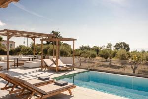 una piscina con mobili da giardino e una piscina di Panagis Villa by Vintage Travel a Karavádhos