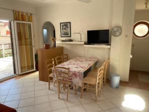 a kitchen and dining room with a table and chairs at Idyllisches Haus an Weingärten 30 m von Kiesstrand in Podobuče