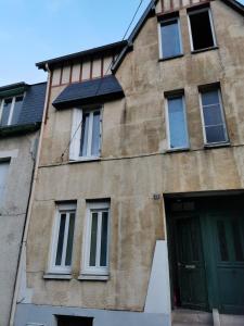 a building with a green door and windows at Entire home - Centre Fécamp - 45 Rosa in Fécamp