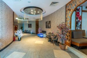 a lobby with tables and chairs and flowers at Maxi Sirius Town 1-Bed Free Pool, Spa, Fast WİFİ Fitness & Beach Access in Aksu +32 photos