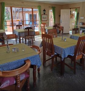 un restaurant avec des tables et des chaises dans une salle dans l'établissement Corea Game Ranch, à Alldays
