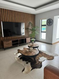 een woonkamer met een tv en een tafel bij The Sanctuary Guest House in East London