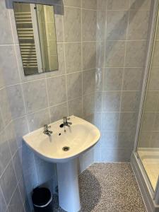 a bathroom with a white sink and a shower at The Red Lion Swanage in Swanage