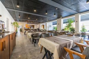 a restaurant with tables and chairs in a room at Dorana Hotel in Kyrenia