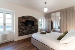 a bedroom with a large bed and a brick wall at Sunflower Apartment -The House Of Travelers in Como