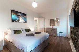 a bedroom with a large white bed and a tv at Sunflower Apartment -The House Of Travelers in Como