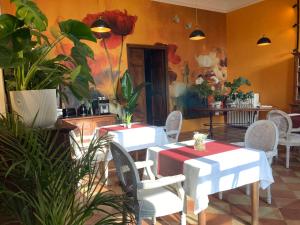 two tables and chairs in a room with plants at Les Ordalies in Castelnaudary