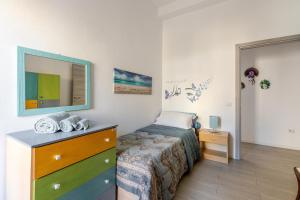 a bedroom with a bed and a dresser with a mirror at Cappuccini apartment lower in Oristano