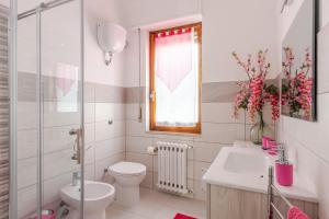 a bathroom with a toilet and a sink and a window at Cappuccini apartment lower in Oristano +15 photos