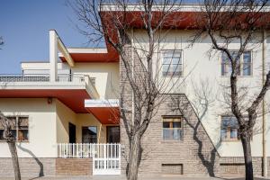 a white building with trees in front of it at Cappuccini apartment lower in Oristano