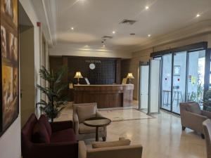 Eine Lobby mit Wartebereich mit Stühlen und einem Tresen in der Unterkunft Hôtel LE CONSUL in Tunis