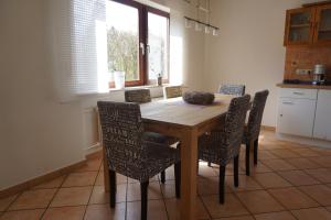 a kitchen with a wooden table and chairs at Haus Eifeldolomiten - Ankommen und Wohlfühlen in Gerolstein