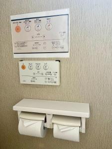 een toilet in een badkamer met een bord erboven bij U&T House in Beppu