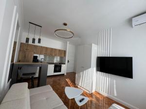 a living room with a white couch and a tv at Moft Hotel Apartments Free Parking Self Check-In in Oradea