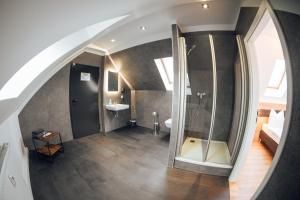 an attic bathroom with a shower and a sink at Palais in Erfurt