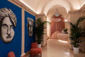 a hallway with paintings of faces on the wall at Cloud 7 Roma Hotel in Rome