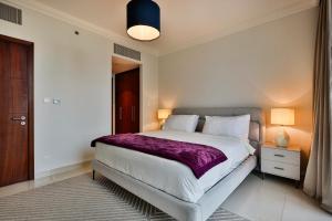 a bedroom with a large bed with a purple blanket at " Luxury Stay in Downtown Dubai - Stunning Views & Prime location ! in Dubai +18 photos