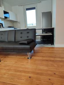 a black couch in a living room with a table at Entire home - Centre Fécamp - 36 Elena in Fécamp