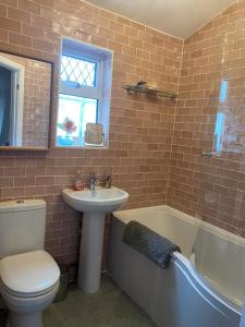 a bathroom with a toilet and a sink and a tub at Picton House: Charming 3 bed property in quiet location in Ramsgate