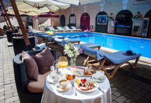 ein Tisch mit Speisen und Getränken neben einem Schwimmbecken in der Unterkunft Hotel Otrada in Odessa