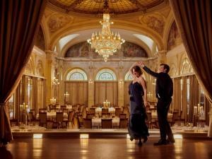 a man and a woman dancing in a ballroom at Fairmont Le Montreux Palace in Montreux