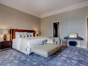 a bedroom with a large bed and a chair at Fairmont Le Montreux Palace in Montreux