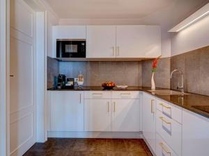 a kitchen with white cabinets and a sink at Fairmont Le Montreux Palace in Montreux