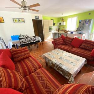 ein Wohnzimmer mit Sofa und Tisch in der Unterkunft Maison au calme piscine mer au coeur de la nature U Nuciolu in Talasani