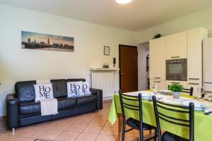 een woonkamer met een tafel en een bank bij Cozy Flat with Private Garden in Paderno Dugnano +6 foto's