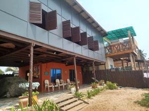 a house with a balcony and tables and chairs at Adinam's Beach Retreat in Nyanyanu +19 photos