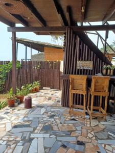 a stone patio with two chairs and a table at Adinam's Beach Retreat in Nyanyanu
