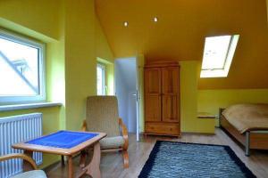a yellow room with a table and a bed at Domek gościnny Biel in Krościenko