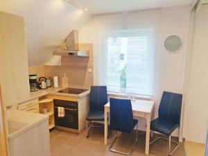 a kitchen with a table and four blue chairs at Mini Wohlfühlnest in Edertal +10 photos